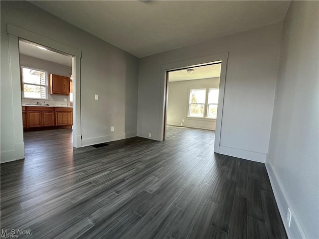 spare room with dark hardwood / wood-style flooring and sink