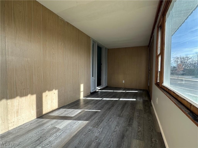 interior space featuring dark hardwood / wood-style floors and wooden walls