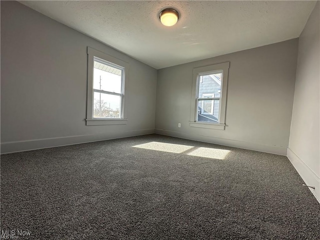 carpeted empty room with a textured ceiling