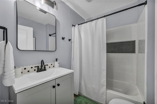 full bathroom with vanity, toilet, shower / bathtub combination with curtain, and a textured ceiling