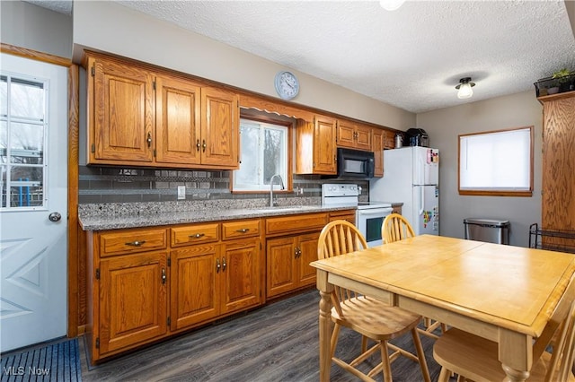 kitchen with white appliances, a textured ceiling, dark hardwood / wood-style flooring, decorative backsplash, and sink