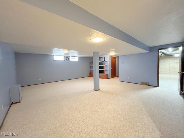 basement featuring light carpet