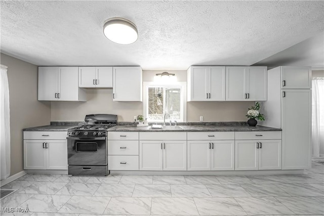 kitchen featuring black gas range, white cabinetry, and sink