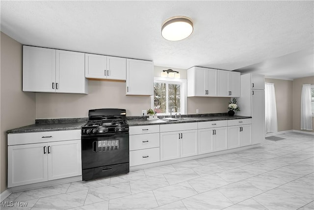 kitchen with white cabinets, black range with gas stovetop, sink, and a textured ceiling