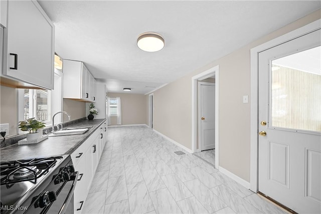 kitchen featuring white cabinets, sink, and gas range