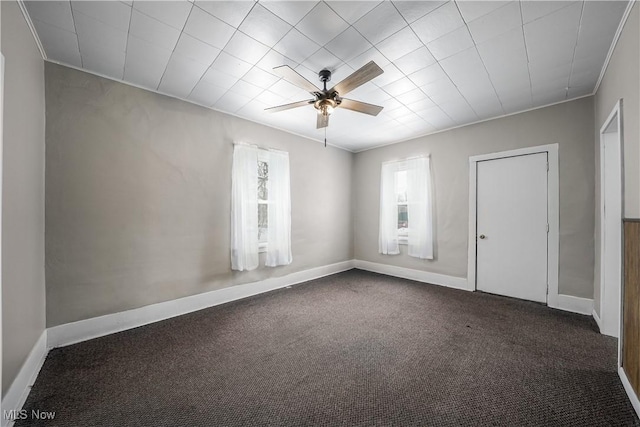 spare room with dark colored carpet and ceiling fan