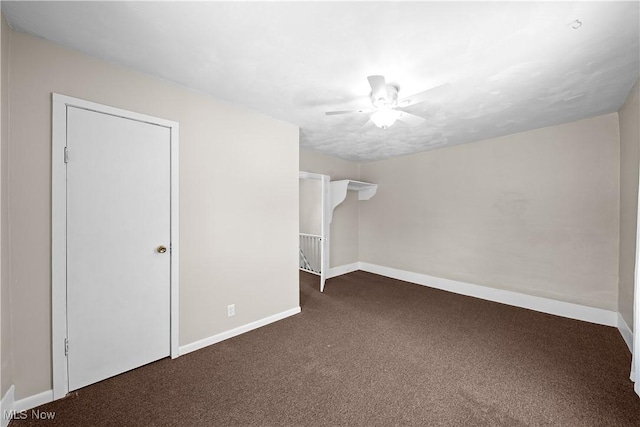 interior space with ceiling fan and dark colored carpet