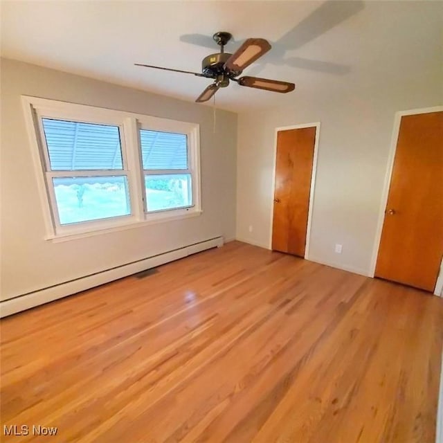 unfurnished bedroom with a baseboard heating unit, ceiling fan, and light wood-type flooring