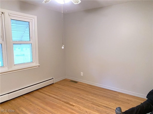 unfurnished room featuring light hardwood / wood-style floors, a baseboard heating unit, and ceiling fan