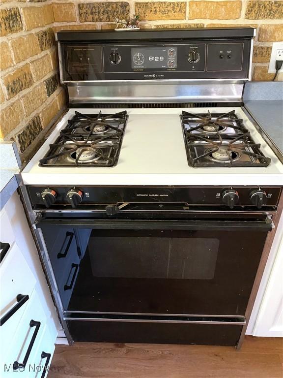 interior details with range with gas cooktop and dark hardwood / wood-style floors