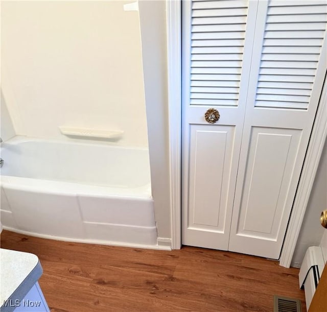 bathroom featuring hardwood / wood-style flooring and a washtub