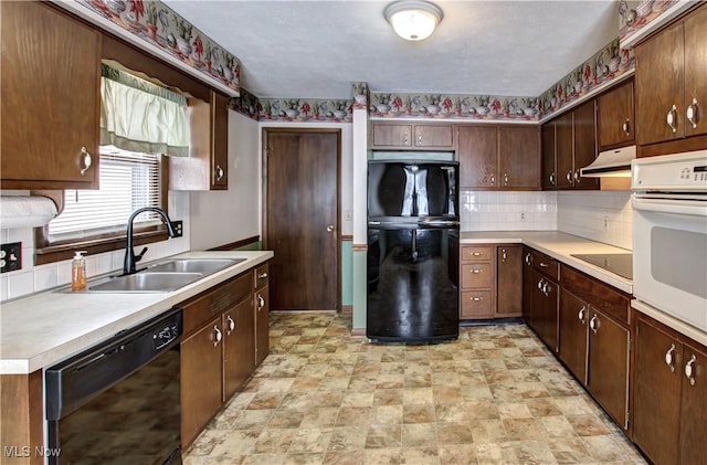 kitchen featuring dark brown cabinets, sink, backsplash, and black appliances