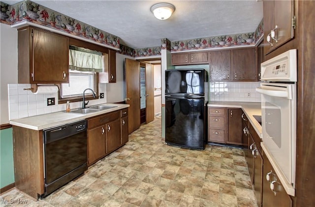 kitchen featuring black appliances, dark brown cabinets, sink, and a textured ceiling