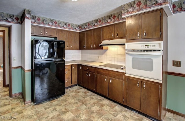 kitchen with dark brown cabinets, a textured ceiling, and black appliances