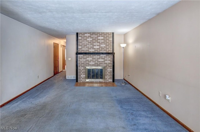 unfurnished living room featuring carpet floors, a textured ceiling, and a brick fireplace