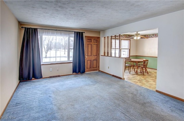 unfurnished room with carpet flooring, a textured ceiling, and ceiling fan