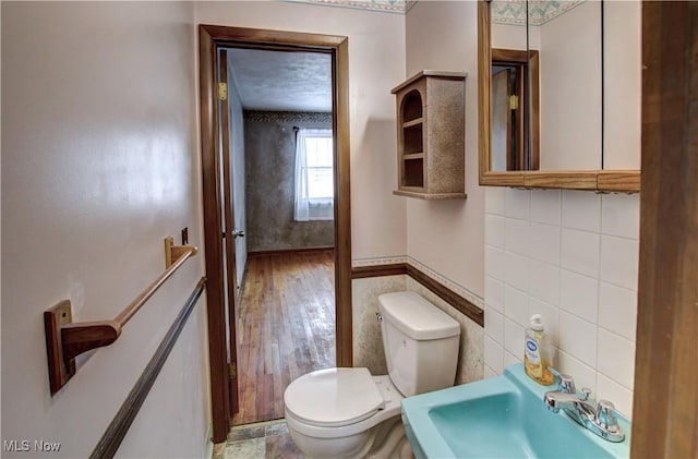 bathroom featuring backsplash, toilet, tile walls, and sink