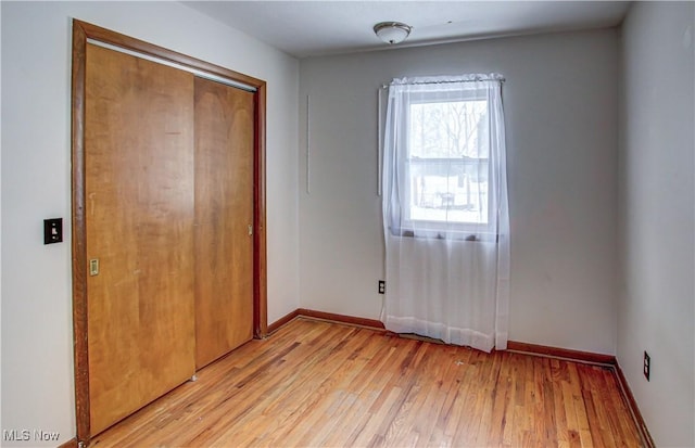 unfurnished bedroom with a closet and light hardwood / wood-style floors