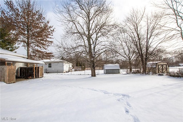 yard covered in snow with a storage unit