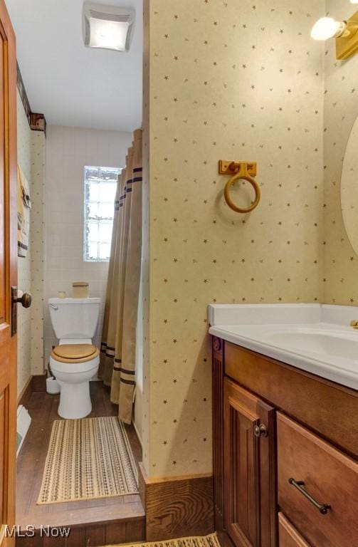 bathroom featuring a shower with curtain, vanity, and toilet