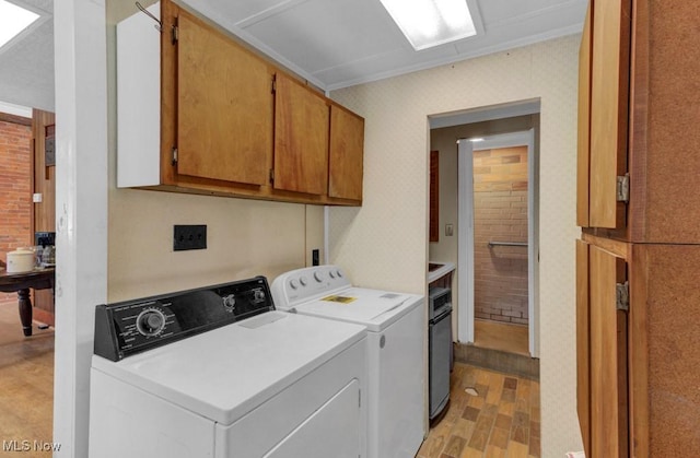 washroom featuring separate washer and dryer, cabinets, and light wood-type flooring