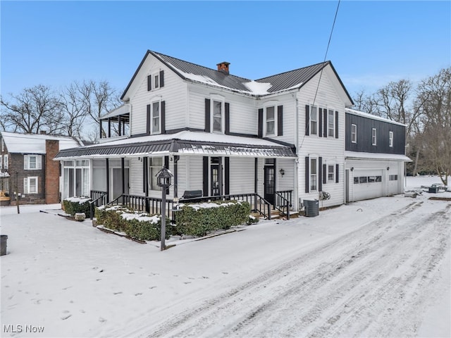 view of front of property with a porch, a garage, and cooling unit