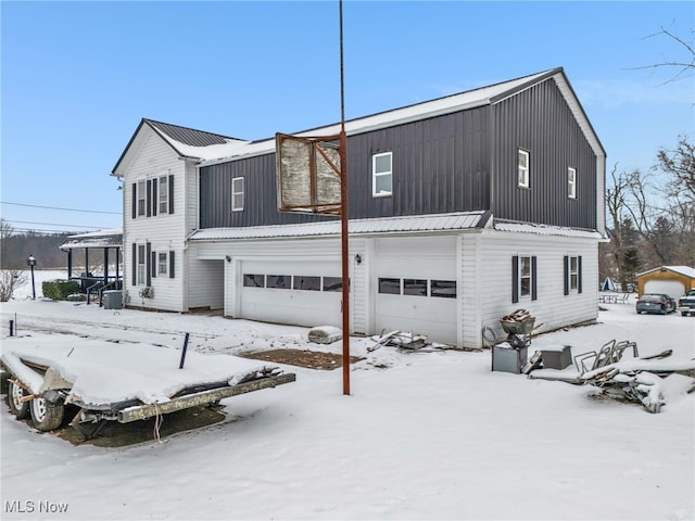 snow covered property with a garage