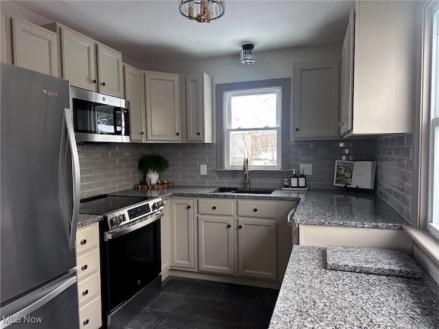 kitchen with white cabinets, sink, decorative backsplash, light stone countertops, and stainless steel appliances