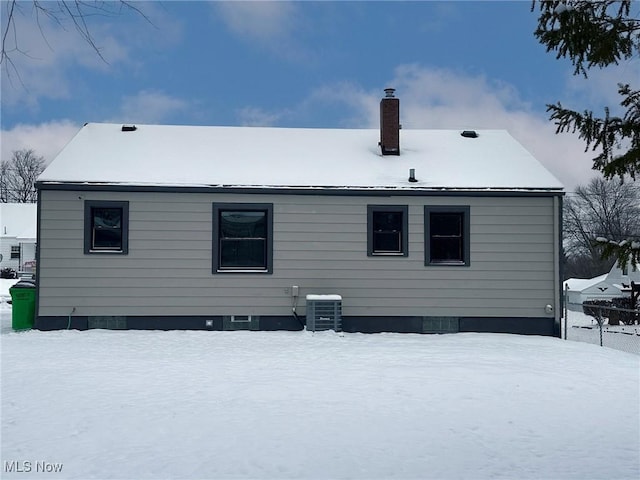 snow covered house featuring central air condition unit