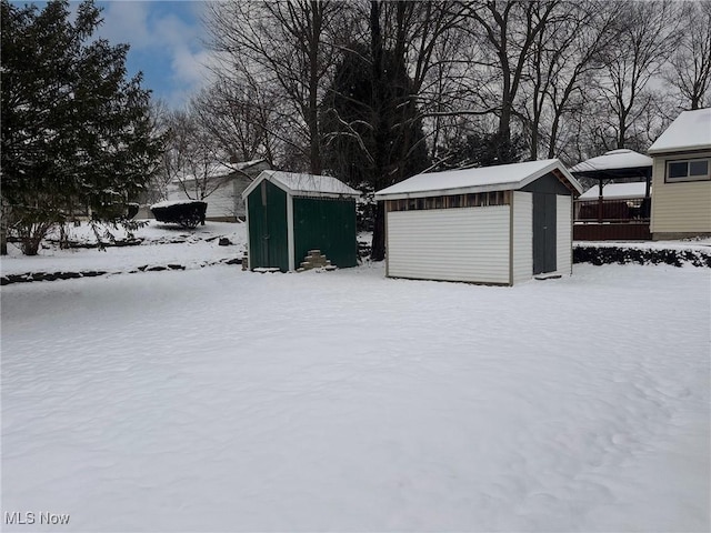 yard covered in snow with a storage shed