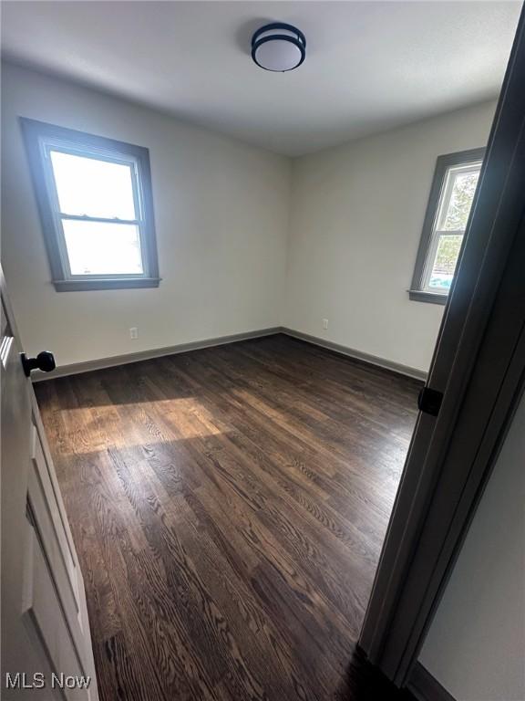 empty room with dark wood-type flooring