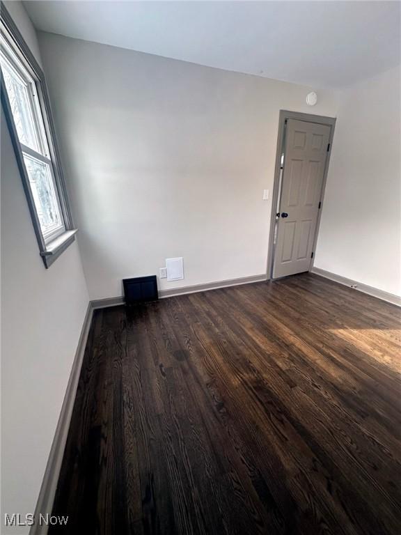 spare room with dark wood-type flooring