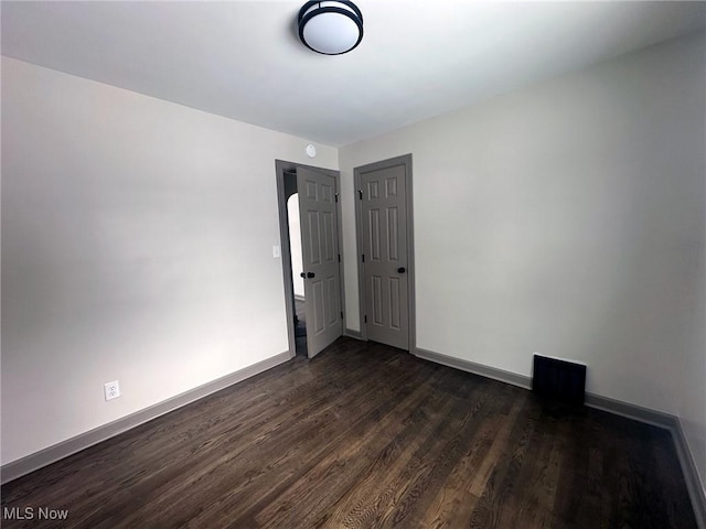 spare room with dark wood-type flooring