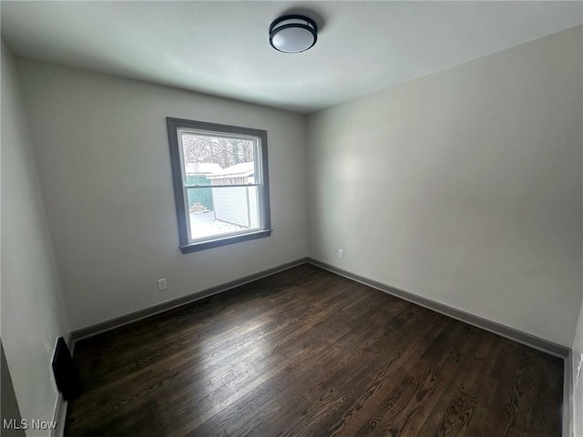 spare room featuring dark wood-type flooring