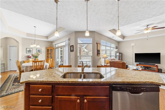 kitchen featuring stainless steel dishwasher, a raised ceiling, a textured ceiling, and sink