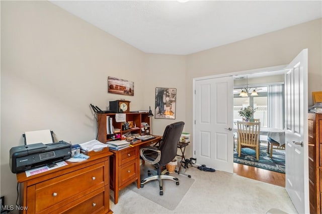 carpeted office space with a chandelier