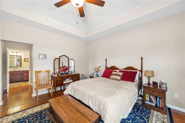 bedroom with hardwood / wood-style flooring, ceiling fan, and connected bathroom