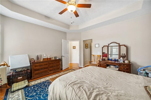 bedroom with a raised ceiling and ceiling fan