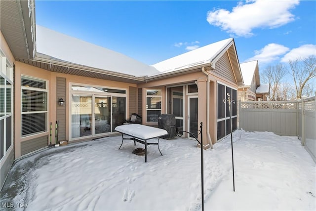 snow covered patio with a sunroom