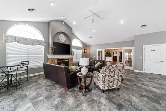 living room featuring french doors, a fireplace, ceiling fan, and a wealth of natural light