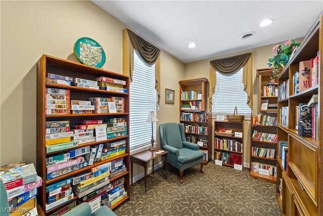 sitting room featuring dark carpet