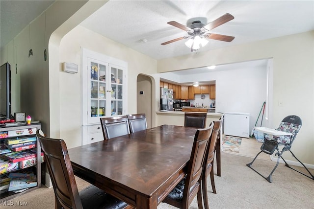 dining area with light colored carpet and ceiling fan