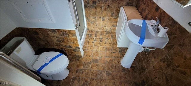 bathroom with tile walls and toilet