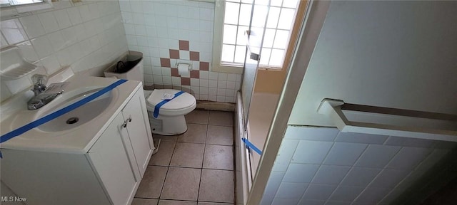 bathroom featuring tile patterned flooring, vanity, tile walls, and toilet