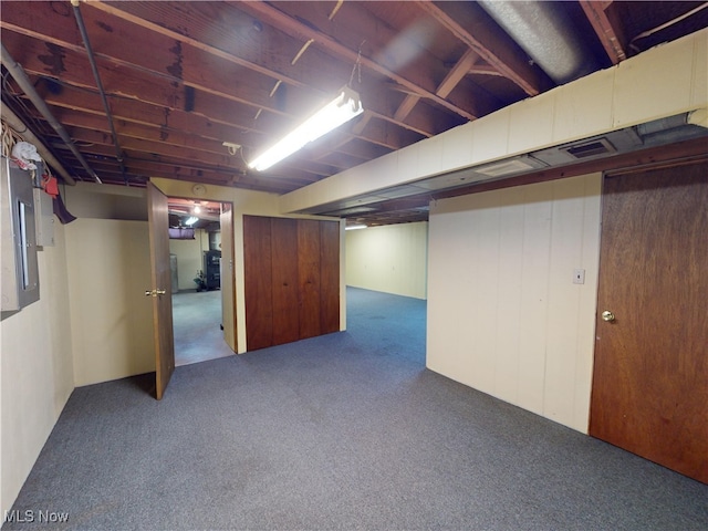 basement with electric panel and carpet