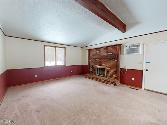 unfurnished living room featuring a textured ceiling, vaulted ceiling with beams, an AC wall unit, light carpet, and a brick fireplace