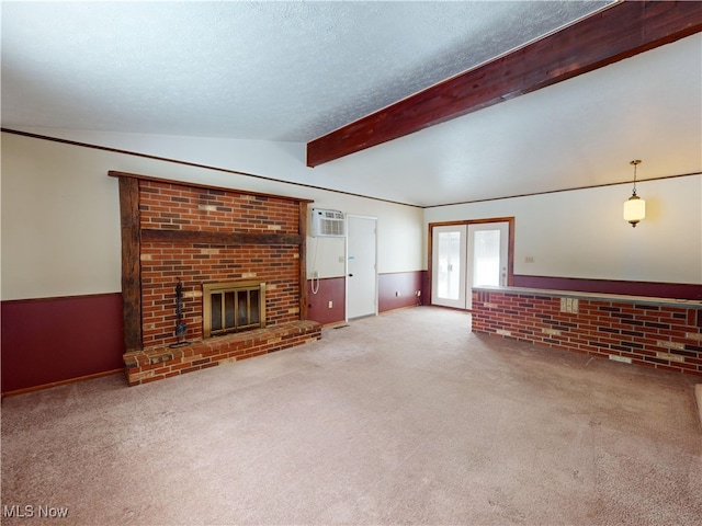 unfurnished living room featuring french doors, a brick fireplace, lofted ceiling with beams, and carpet