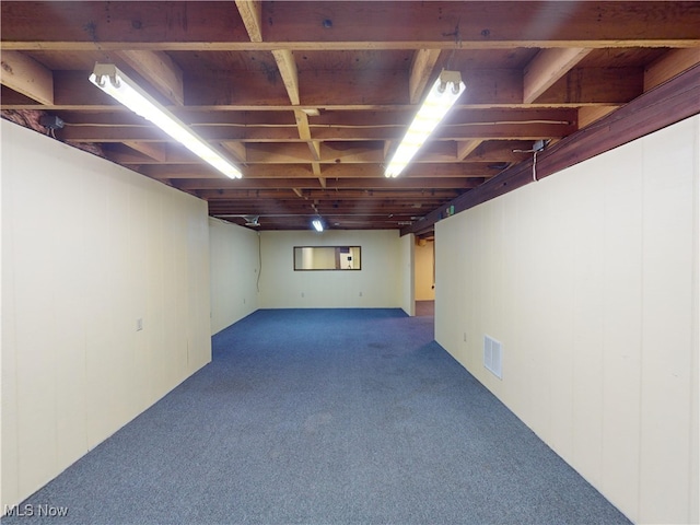 basement featuring carpet floors and rail lighting