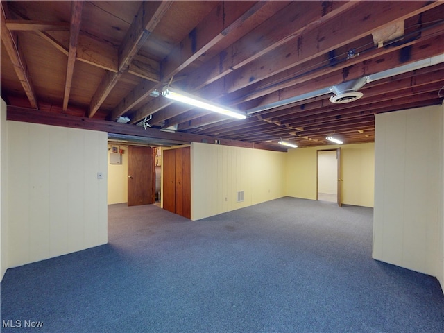 basement with wooden walls and carpet floors