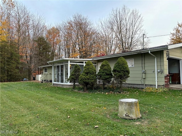 back of property with a lawn and a sunroom